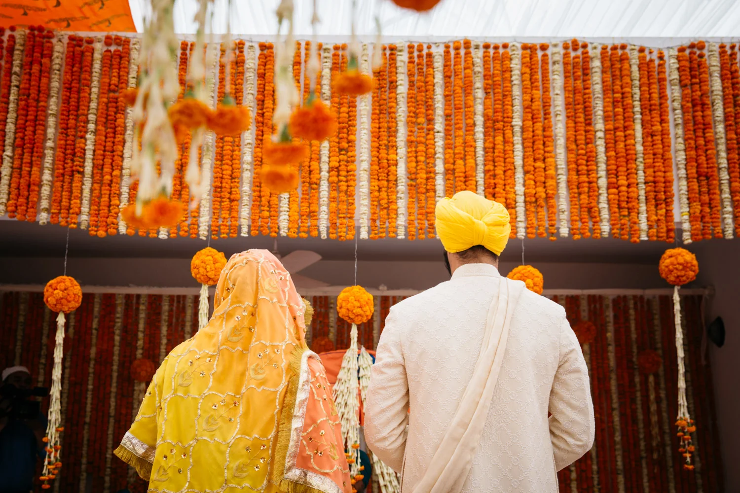 Couple facing wall of marigolds